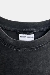 Camiseta de manga larga, corte regular, color negro con efecto lavado o acid wash. Presenta un estampado frontal en rojo con la palabra "LOVE" estilizada.