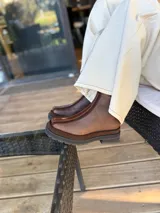 Bota corta de cuero en tonos chocolate, con diseño de paneles texturizados y suela track robusta de goma.