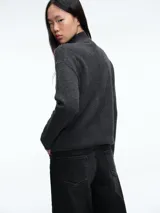 Sweater de cuello alto confeccionado en tejido de lana y cachemira, de corte holgado con mangas largas y terminaciones acanaladas en puños y ruedo.