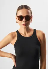 Lentes de sol redondos con montura gris translúcido y lentes verdes. Fabricados con acetato biodegradable y lentes de PMMA reciclado.