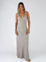 Vestido largo de lino con diseño de rayas diagonales en tonos beige y blanco, escote en V y tirantes anchos con lazos ajustables en los hombros.