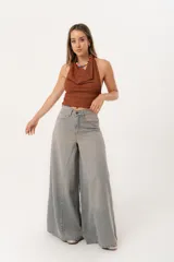 Jean súper campana de tiro alto, color celeste vintage, con pierna extra ancha y caída fluida. Cuenta con bolsillos delanteros y traseros, y cierre frontal con cremallera y botón metálico.