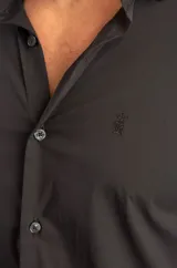 Camisa de manga larga en tejido de tricolina con elastano, color negro, de corte entallado y diseño liso con cierre frontal de botones.