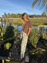 Remera color beige de algodón, con cuello redondo y logo 'AW' bordado en el frente.