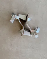 Sandalia de taco cuadrado alto, con diseño de punta cuadrada, tira delantera ancha y tira ajustable en el tobillo con hebilla metálica.