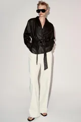 Chaqueta ZARA Woman Collection efecto piel en color marrón oscuro, de manga larga y cuello smoking. Cuenta con cinturón ajustable del mismo material para atar en la cintura y forro interior.