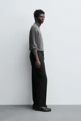 Jersey negro de punto fino con cuello alto y manga larga.