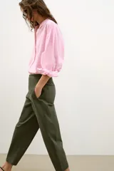 Pantalón de tiro medio con diseño barrel, pernera holgada que se estrecha hacia el tobillo, bolsillos delanteros y bolsillos de plastrón en la espalda. Confeccionado en tejido con textura de espiga, cuenta con cierre frontal de cremallera, botón interior y gancho.