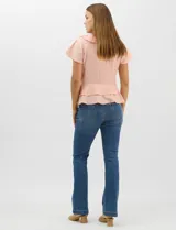 Blusa de satén color rosado con acabado texturizado, escote en V con volados, mangas cortas acampanadas y diseño péplum de doble nivel en la parte inferior.