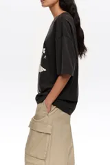 Remera de corte recto y diseño oversize, confeccionada en algodón orgánico. Presenta escote redondo, mangas cortas y estampa frontal en blanco y negro con la ilustración de bailarinas y la inscripción "Bimba y Lola Dancers".