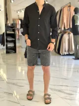 Camisa de lino color beige, de manga larga con puños arremangados y cuello mao. Cuenta con cierre frontal de botones y diseño clásico.