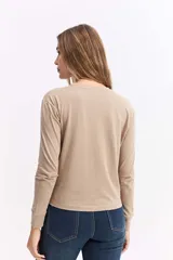 Remera de manga larga en color beige, con cuello redondo y corte recto, confeccionada en algodón.