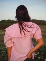 Blusa blanca de lino, de manga corta, con cuello marinero amplio decorado con estampado azul.