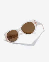 Gafas de sol Hawkers unisex, modelo Miranda, con montura color arena translúcido y lentes marrones.