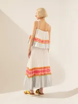 Pollera larga plisada color blanco, con cintura elastizada y estampado multicolor en los bordes del ruedo.