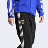 Pantalón deportivo Adidas Originals de la selección argentina, color negro con las icónicas tres tiras blancas laterales. Presenta el escudo de la AFA bordado en el muslo y corte clásico con cintura elástica y cordón de ajuste.