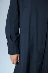 Trench midi color negro, confeccionado en mezcla de algodón y nylon con acabado repelente al agua. Presenta diseño con tajos laterales, bolsillos internos y etiqueta de marca en la espalda.