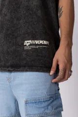 Remera de algodón con efecto desgastado acid wash, corte semi-oversize, cuello redondo y estampa gráfica pequeña en la parte inferior frontal.