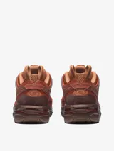 Championes Salomon modelo ACS Pro, en tonos rojizos y marrones con diseño inspirado en el desierto. Presentan una estructura técnica con malla transpirable, refuerzos laterales tipo jaula y suela robusta de alto rendimiento.