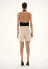 Body negro de corte ajustado con espalda descubierta y cuello halter, confeccionado en tejido elástico con cierre inferior.