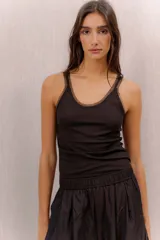 Musculosa de canalé negra con tirantes anchos de tela translúcida y escote redondo.