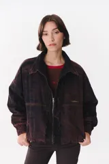 Campera de denim azul con corte oversized, cierre frontal y cuello de piel sintética marrón desmontable. Presenta detalles de volados en el frente, puños elásticos y logo bordado en el pecho.