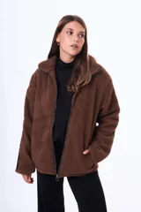 Campera de corderito sintético color blanco, con detalles en color marrón en el cierre, cuello y mangas. Posee cierre frontal y bolsillos laterales.