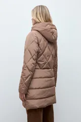 Campera acolchada de corte largo con diseño capitoneado en forma de rombos, cierre frontal con cremallera y capucha integrada.