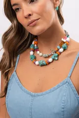 Collar corto compuesto por cuentas grandes de piedra turquesa irregular, alternadas con cuentas circulares blancas, naranjas y lilas.