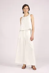 Blusa blanca de broderie con cuello redondo y sin mangas.