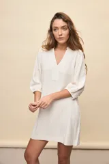 Vestido corto negro de silueta relajada, con escote en V y mangas 3/4 levemente abullonadas.