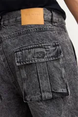 Pantalón tipo jean de corte baggy con diseño cargo, presenta bolsillos laterales amplios con solapa y costuras reforzadas. Confeccionado en denim de algodón con acabado lavado.