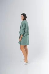 Bata kimono gris claro de algodón con volados en mangas y ruedo. Tiene mangas al codo y lazo de algodón para ajustar en la cintura.