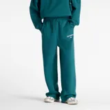 Pantalón de jogging New Balance de corte holgado, color verde petróleo, con cintura elástica ajustable mediante cordón, bolsillos laterales y detalle de línea vertical blanca en los laterales. Presenta el logo de la marca bordado en la parte frontal.