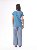 Remera blanca de manga corta con escote en V, de tejido ligero y ligeramente traslúcido.