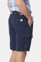 Bermuda cargo color beige con bolsillos laterales y traseros. Se ajusta a la cintura con cinturón de cuero marrón.