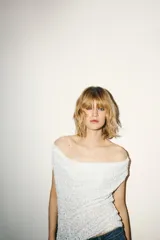 Top blanco sin mangas con escote drapeado y lentejuelas.