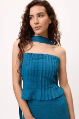 Conjunto de top strapless y falda midi con volados, color fucsia, con textura plisada y bufanda al cuello.