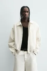 Cazadora de algodón color crema, corte regular fit, con cuello solapa, cierre frontal de cremallera y puños y bajo elásticos. Presenta bordado a tono en el delantero y espalda, y un parche combinado a contraste en la espalda.