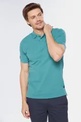 Remera polo de piqué color verde azulado, de manga corta con puños acanalados, cuello clásico con cierre de dos botones y detalle de bordado pequeño en la manga.