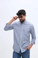 Camisa de manga larga color rosado, con cuello abotonado, cierre frontal de botones y un bolsillo ojal en el pecho.