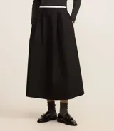 Pollera midi evasé color negro confeccionada en tricolina de algodón sostenible con elástico en la cintura y textura empapelada.