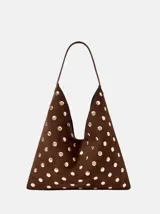 Bolso de hombro con diseño triangular, confeccionado en gamuza marrón y decorado con tachas metálicas doradas circulares en toda su superficie.