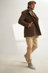 Saco de lana color tostado, con solapa, doble abotonadura, bolsillos, canesú y charreteras. Prenda de uso diario.