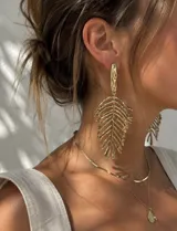 Aros colgantes dorados con diseño en forma de hoja texturada.