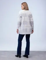 Blazer largo con estampado de cuadrillé en tonos grises y negros. Tiene cuello solapa, abertura central y bolsillos delanteros. Marca Dictionary.