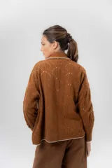 Saco tejido de lambswool color marrón, con diseño inspirado en kimono, mangas largas y delicados calados en toda la prenda. Cuenta con bordes en contraste.