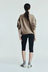 Buzo de tejido de algodón de peso medio, color marrón topo, con cuello redondo y hombros caídos. Presenta puños y bajo en punto acanalado.