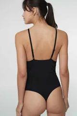 Body colaless de microfibra gloss con estampado de cebra en tonos beige y rosado. Presenta copas triangulares con bordes de puntilla, relleno extraíble, cierre en la entrepierna con broches de presión y breteles ajustables.