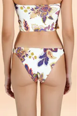 Parte inferior de bikini con cobertura media y diseño de corte clásico. Presenta un estampado botánico multicolor sobre fondo blanco.
